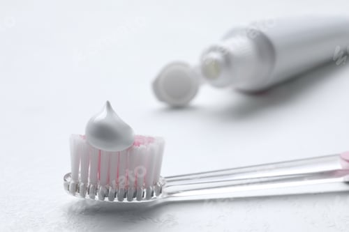 Preview: Brush with toothpaste and tube on white background, closeup