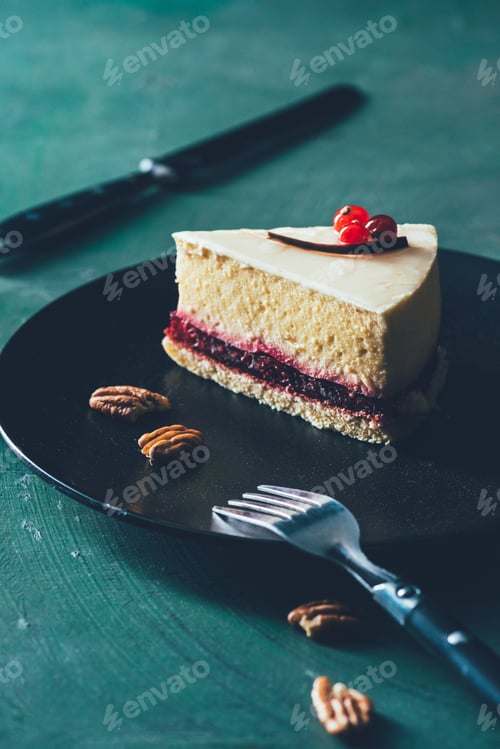 Preview: close up view of piece of cake on plate with hazelnuts and fork