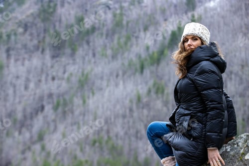 Preview: A woman outside in nature takes in the view of beautiful, snow covered mountains