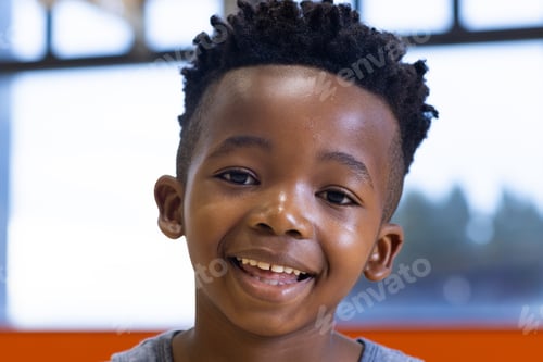 Preview: Smiling boy in school classroom, looking at camera, feeling happy and confident