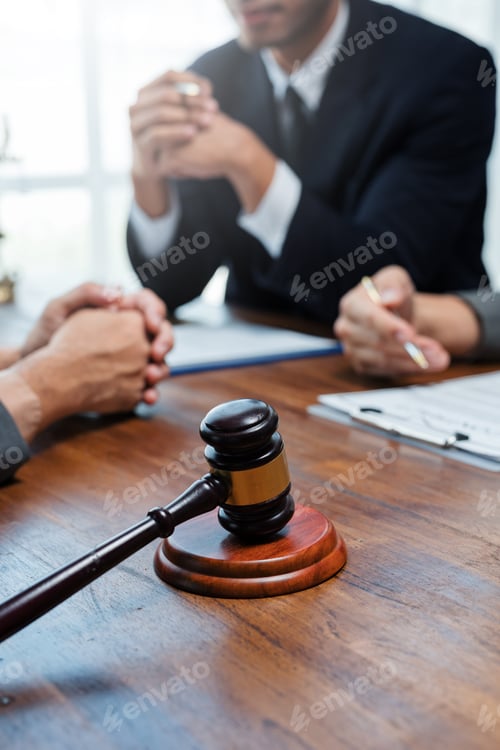 Preview: Judge gavel on table during business meeting with lawyers discussing about contract
