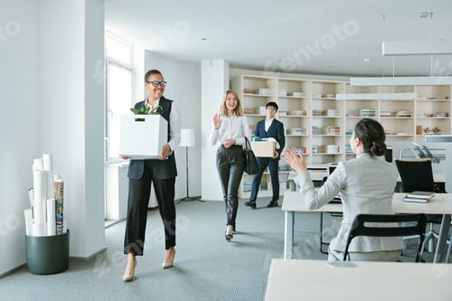 Preview: Group of young happy intercultural colleagues with boxes returning to work