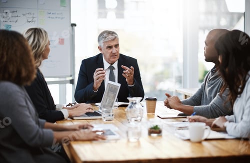 Preview: Addressing a few topics. Shot of a group of businesspeople having a meeting in an office.