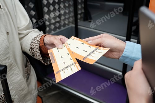 Preview: Hands of mature passenger and young bus conductor with tickets