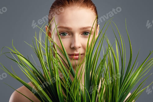 Preview: Red-Haired Girl Posing With Green Plants Standing Over White Background
