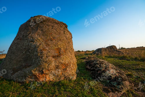 Preview: A small pile of stones in a green-yellow field against the background of a sky in Ukraine
