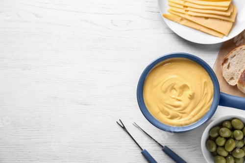 Preview: Flat lay composition with cheese fondue and products on white wooden table, space for text