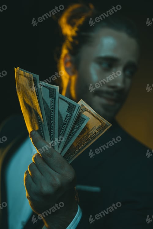 Preview: young caucasian man in tuxedo holding us dollar banknotes