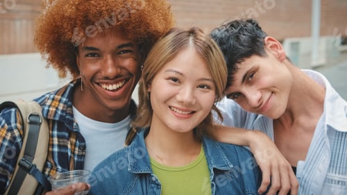 Preview: Group of multi-ethnic happy friends, two guys and girl, looking at the camera with smile