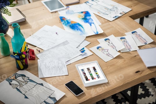 Preview: smartphone, digital tablet with multimedia website and fashion sketches on table
