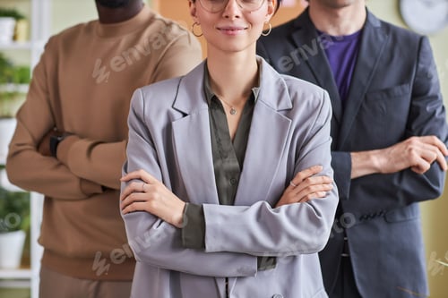 Preview: Professional business team in office posing confidently with arms crossed