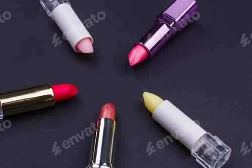 Preview: Different lipsticks forming a circle on black background.