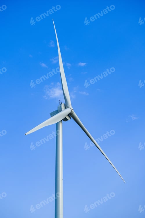 Preview: Vertical closeup shot of the wind turbine on a blue sky background on a sunny day