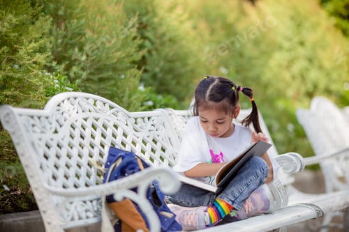 Preview: Back to school. Asian girl reading a book. Primary school students after classes learning homework.