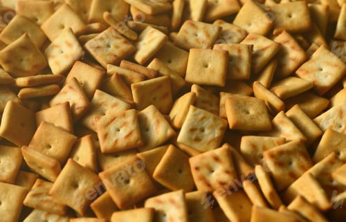 Preview: A lot of small cookies are square shaped. A pattern of a yellow salt cracker