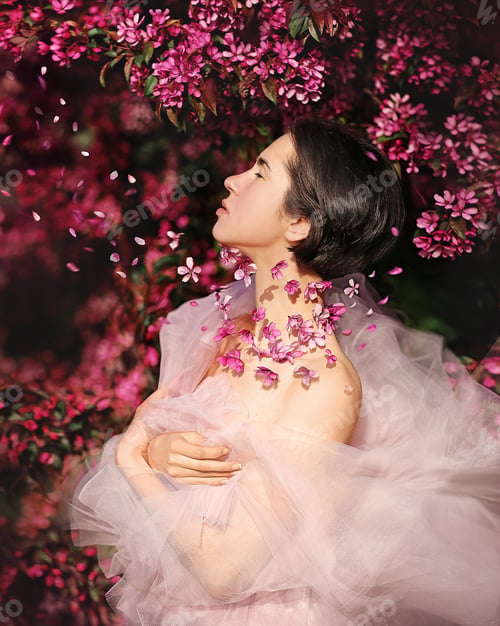 Preview: spring.beautiful girl in a delicate dress.flowers fly around the girl's neck