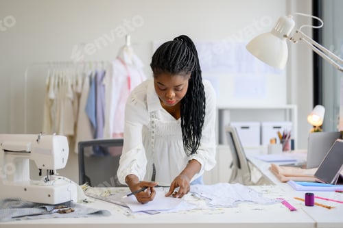 Preview: Happy dressmaker designer working in workshop studio