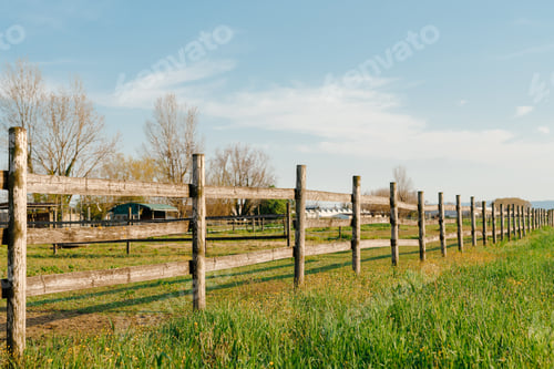 Preview: An old wood fence with a green country field behind it.
