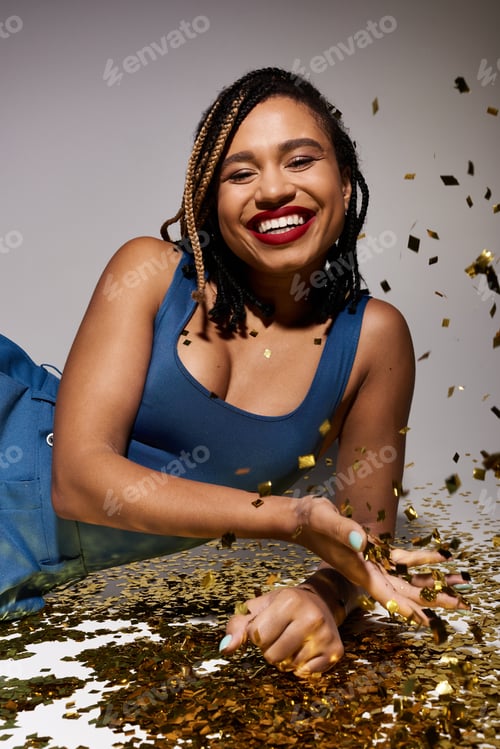 Preview: Young Black woman with braids and red lips enjoying confetti in a studio
