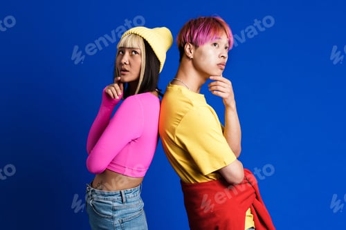 Preview: Asian puzzled couple with multicolored hair posing back to back
