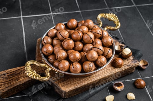 Preview: Macadamia nuts in a shell ready to eat. Black background. Top view