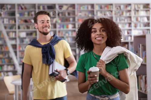Preview: Happy young people with books in library