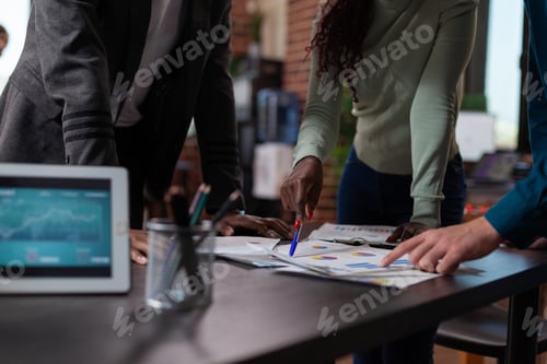 Preview: Closeup of diverse team analyzing papers with marketing statistics