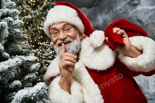 Preview: Jolly Santa Claus sharing a secret in a winter wonderland surrounded by snowy trees