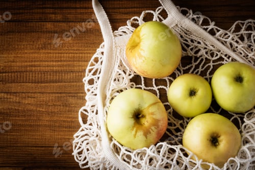 Preview: Cotton net bag with fruits apples on dark wooden background . Sustainable lifestyle.