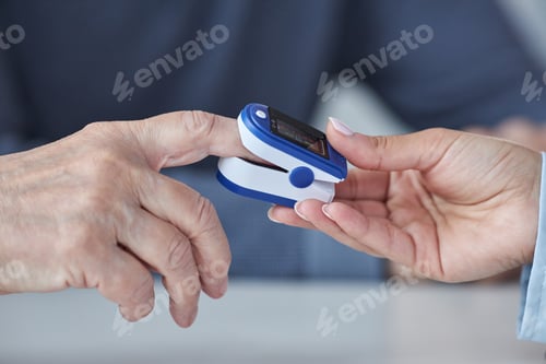 Preview: Doctor putting pulse oximeter on hand