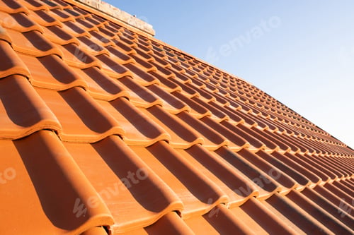 Preview: Overlapping rows of yellow ceramic roofing tiles covering residential building roof
