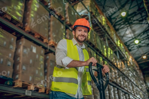 Preview: Good Mood. Worker In A Vest And Helmet Pushing The Loader And Looking Positive