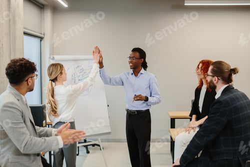 Preview: Business team celebrating success giving high five after meeting