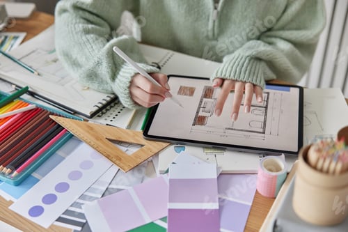 Preview: Cropped image of unrecognizable female architect uses digital tablet and stylus for drawing