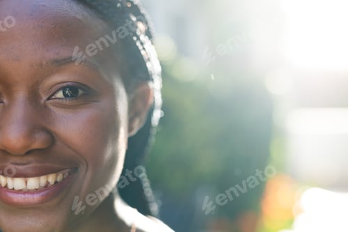 Preview: Half face of happy african american woman standing and smiling in sunny garden, copy space