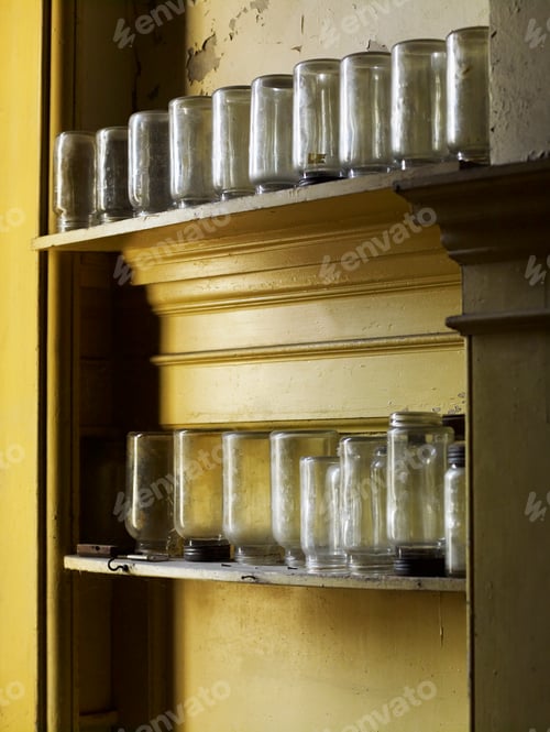 Preview: Shelves storing upturned glass jars in a kitchen.
