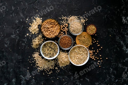 Preview: selection of raw uncooked cereals grains in bulbs with chickpeas oat lentil rice buckwheats