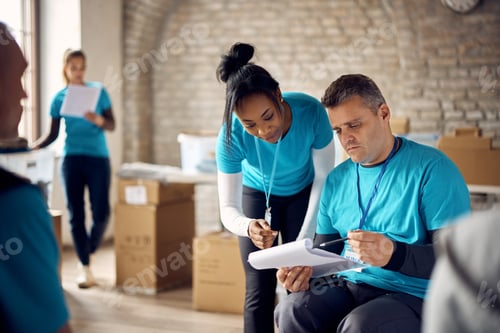 Preview: Two volunteers going through checklist while working at community center.