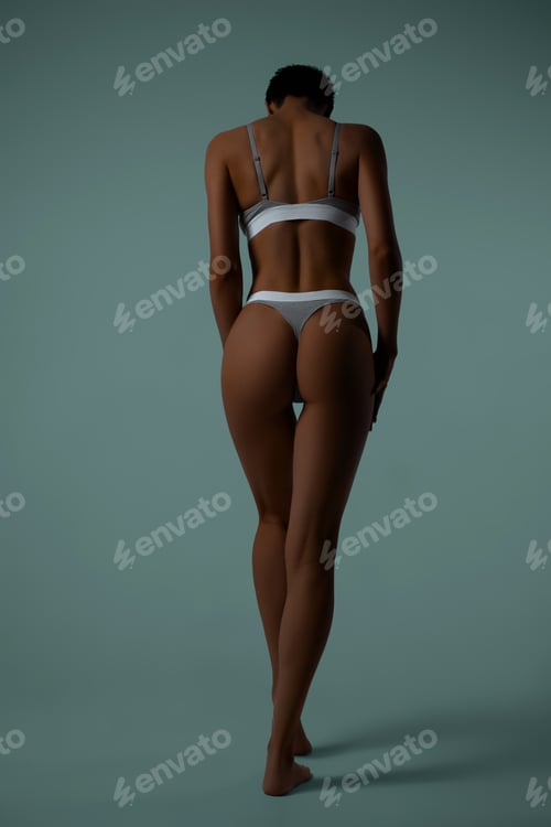 Preview: Young athlete in gray underwear full-length from back on blue background