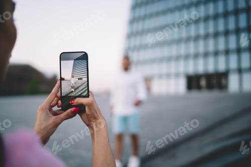 Preview: Anonymous woman taking photo of man on smartphone