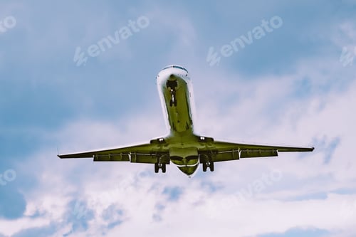 Preview: Low angle shot of an airplane flying in a cloudy sky