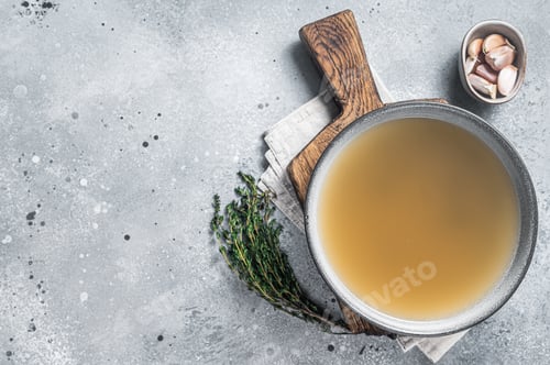 Preview: Bone meat chicken broth in a plate. Gray background. Top view. Copy space