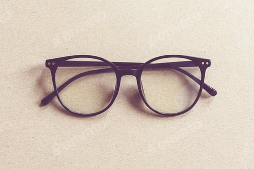 Preview: Eyeglasses on beige cardboard background, minimalist flat lay