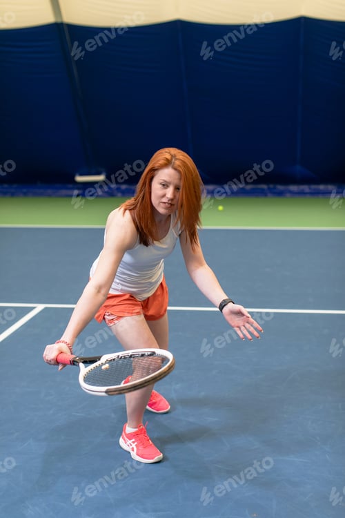 Preview: A woman plays tennis on an indoor court