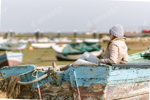 Preview: woman in winter clothes sitting on a fishing boat
