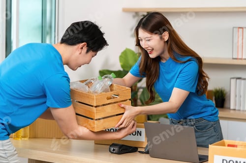 Preview: Donation Initiative. Volunteers joyfully exchanging donation boxes filled with essential items.