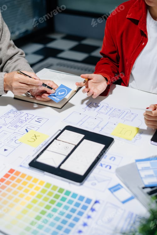 Preview: Close up view of UI developer team brainstorming on their project with laptop, smartphone