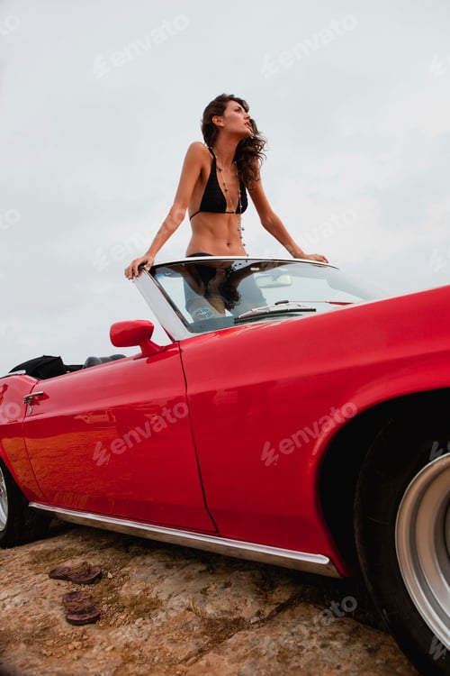Preview: woman standing in an open-topped car