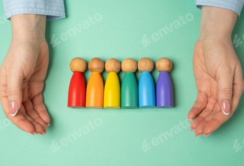 Preview: Hands protect the LGBT community made of rainbow colored human figures.