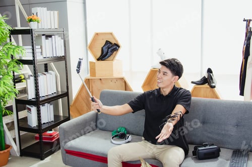 Preview: Online blogger, Asian man, uses a smartphone to record live video vlog to present products